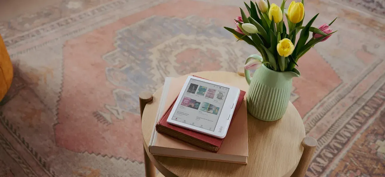 Kobo Clara Colour resting on a stack of books on a side table